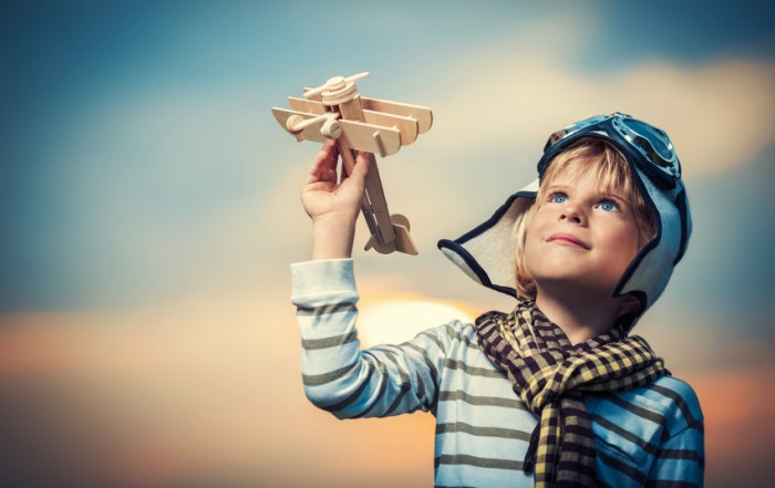 bambino che gioca con un aeroplano di legno