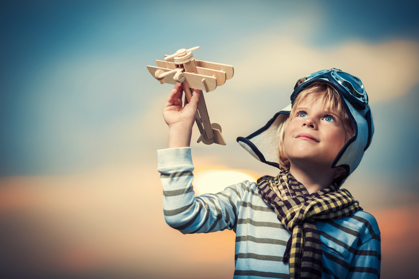 bambino che gioca con un aeroplano di legno