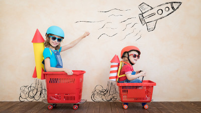 due bambini giocano con i carrelli del supermercato